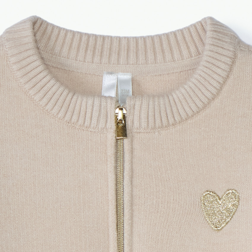 Gemaakt van gebreid materiaal, deze meisjes gilet met rits heeft een stijlvolle pasvorm. 