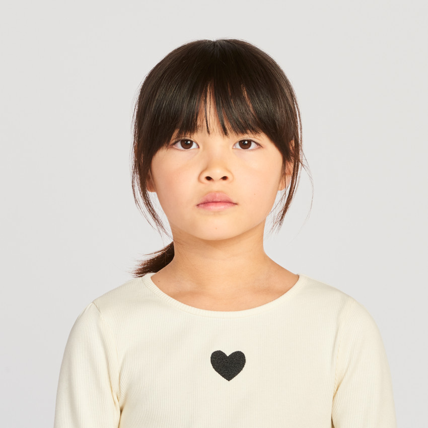 Meisjesjurk met lange mouwen, van twee stoffen, met een bolvormig effect. 