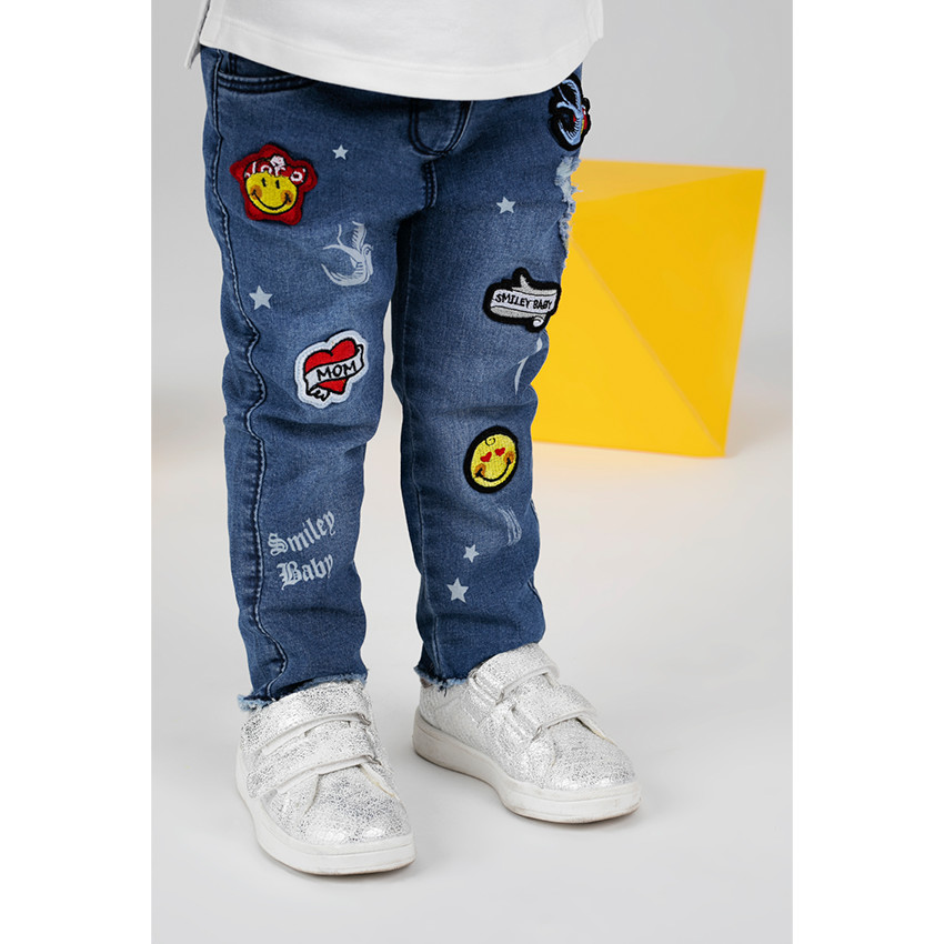 Jeans effet used avec badges Smiley 