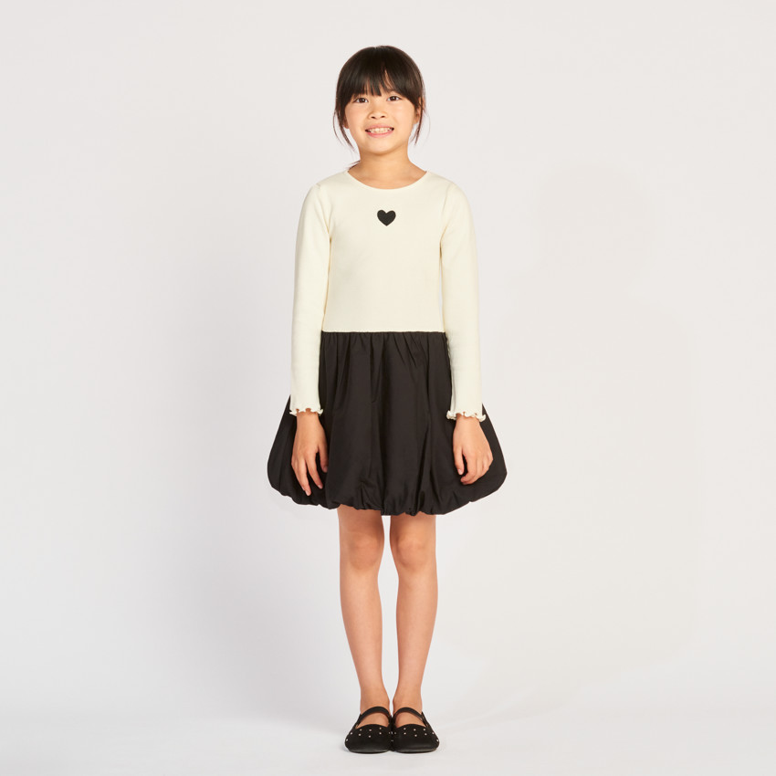 Meisjesjurk met lange mouwen, van twee stoffen, met een bolvormig effect. 