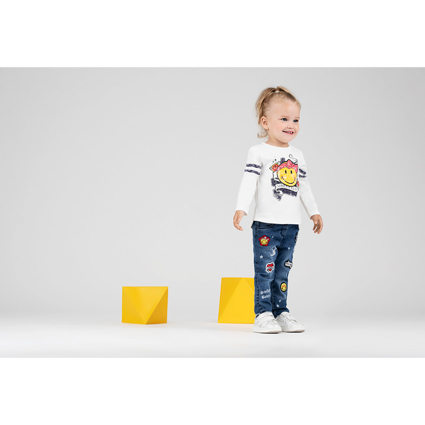 Jeans effet used avec badges Smiley 