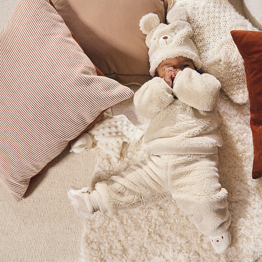 Muts met speelse beer in sherpa voor baby