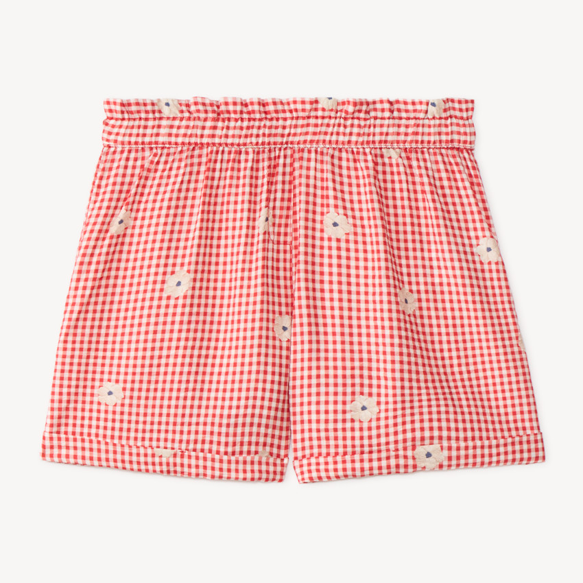 Kort meisje met vichy-stijl en geborduurde bloemen 