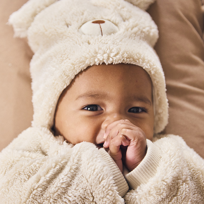 Muts met speelse beer in sherpa voor baby