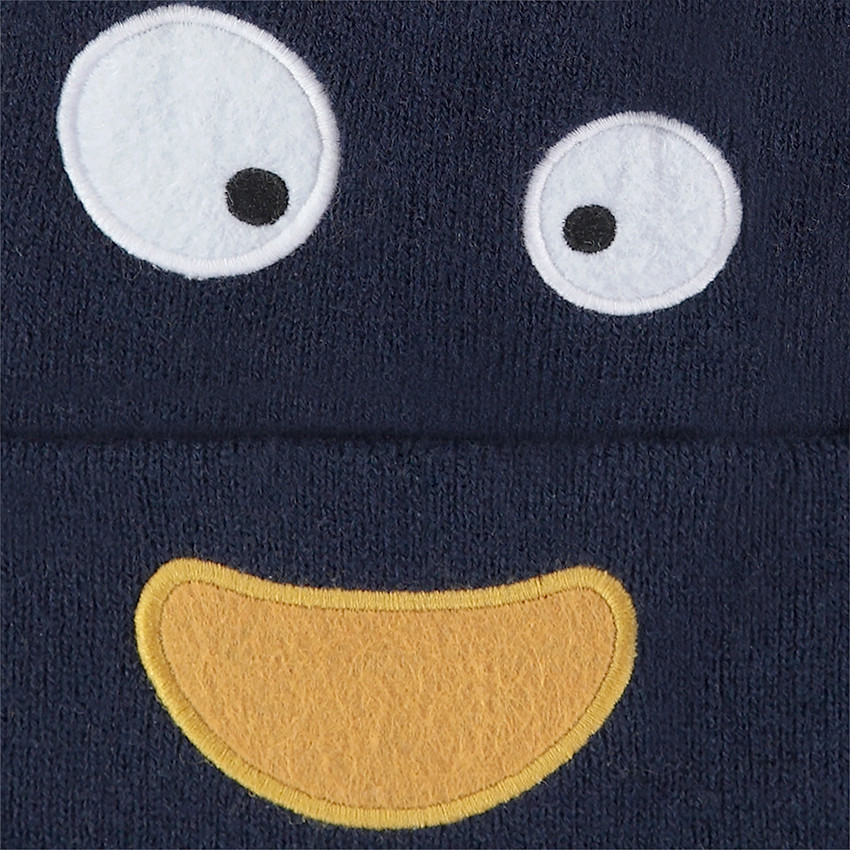 Bonnet en tricot avec pompon jaune et yeux patchés 