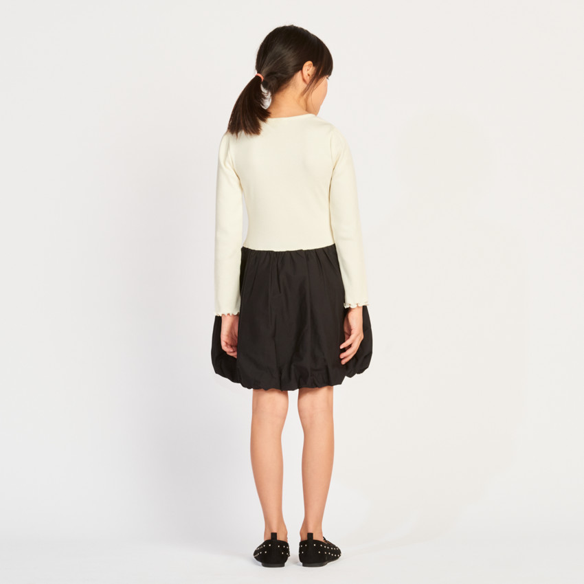 Meisjesjurk met lange mouwen, van twee stoffen, met een bolvormig effect. 